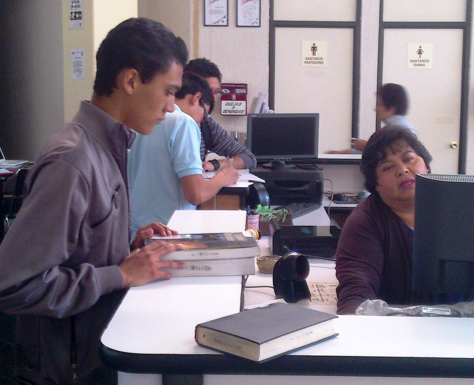 Alumno en atención a alumnos en la biblioteca